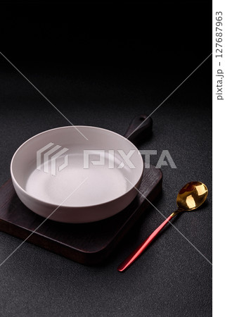 Empty plate with spoon, cutlery for dinner table Empty plate with spoon, cutlery for dinner table 127687963