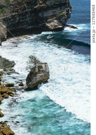 Blue Indian ocean washing the cliff and beach with huge rocks in Bali, Indonesia Blue Indian ocean washing the cliff and beach with huge rocks in Bali, Indonesia 127688468