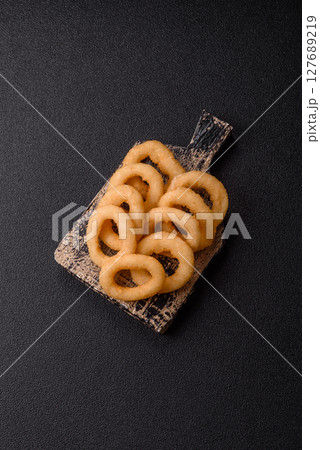 Onion rings or squid rings fries crispy, savory with sauce 127689219
