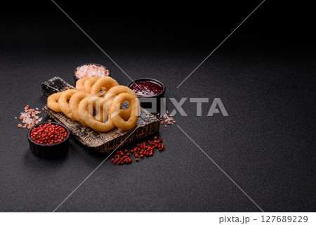 Onion rings or squid rings fries crispy, savory with sauce 127689229