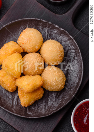 Fried mozzarella or brie cheese with cranberry or raspberry sauce Fried mozzarella or brie cheese with cranberry or raspberry sauce 127689366