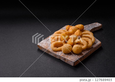 Food, chicken nuggets, onion rings and cheese balls on dark background Food, chicken nuggets, onion rings and cheese balls on dark background 127689403