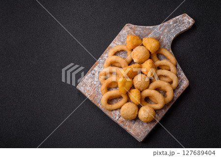 Food, chicken nuggets, onion rings and cheese balls on dark background Food, chicken nuggets, onion rings and cheese balls on dark background 127689404