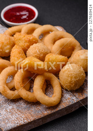 Food, chicken nuggets, onion rings and cheese balls on dark background Food, chicken nuggets, onion rings and cheese balls on dark background 127689414