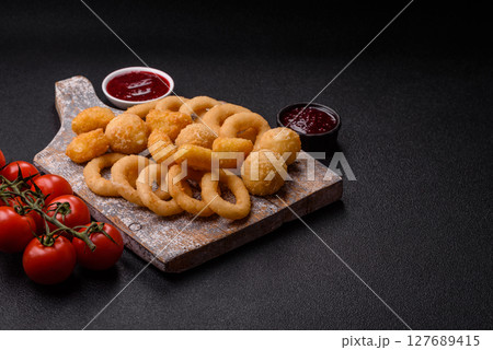 Food, chicken nuggets, onion rings and cheese balls on dark background 127689415