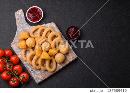 Food, chicken nuggets, onion rings and cheese balls on dark background Food, chicken nuggets, onion rings and cheese balls on dark background 127689416