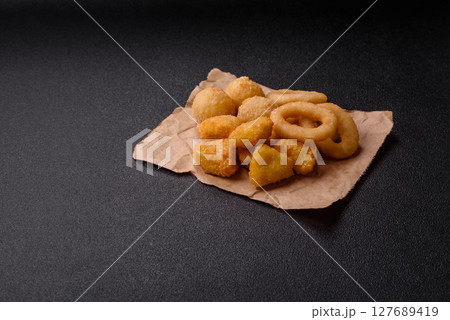 Food, chicken nuggets, onion rings and cheese balls on dark background Food, chicken nuggets, onion rings and cheese balls on dark background 127689419