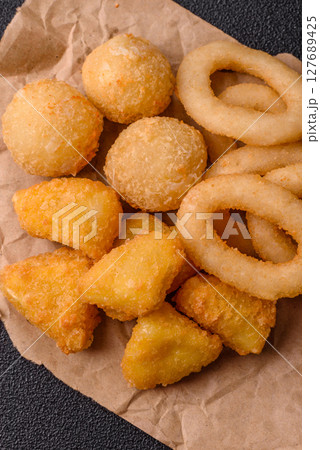 Food, chicken nuggets, onion rings and cheese balls on dark background 127689425