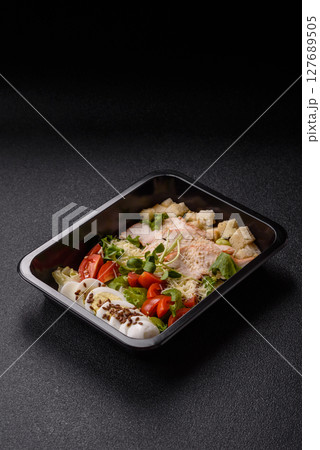 Bowl with caesar salad with chicken, parmesan cheese, tomatoes, croutons, lettuce leaves Bowl with caesar salad with chicken, parmesan cheese, tomatoes, croutons, lettuce leaves 127689505