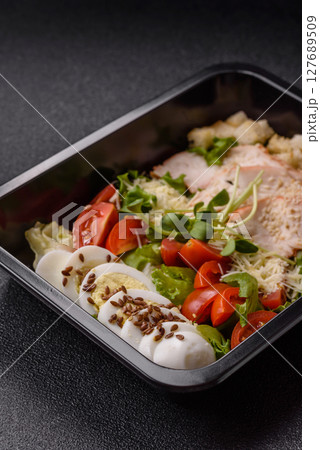 Bowl with caesar salad with chicken, parmesan cheese, tomatoes, croutons, lettuce leaves Bowl with caesar salad with chicken, parmesan cheese, tomatoes, croutons, lettuce leaves 127689509