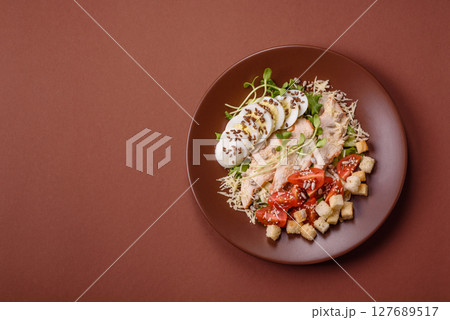 Bowl with caesar salad with chicken, parmesan cheese, tomatoes, croutons, lettuce leaves Bowl with caesar salad with chicken, parmesan cheese, tomatoes, croutons, lettuce leaves 127689517