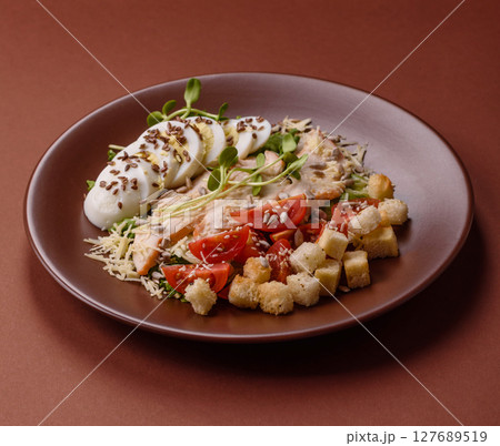 Bowl with caesar salad with chicken, parmesan cheese, tomatoes, croutons, lettuce leaves Bowl with caesar salad with chicken, parmesan cheese, tomatoes, croutons, lettuce leaves 127689519