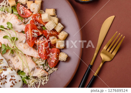 Bowl with caesar salad with chicken, parmesan cheese, tomatoes, croutons, lettuce leaves Bowl with caesar salad with chicken, parmesan cheese, tomatoes, croutons, lettuce leaves 127689524