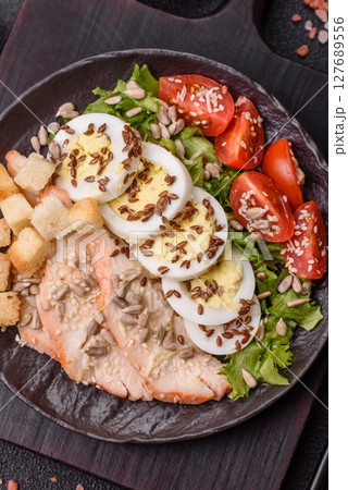 Bowl with caesar salad with chicken, parmesan cheese, tomatoes, croutons, lettuce leaves Bowl with caesar salad with chicken, parmesan cheese, tomatoes, croutons, lettuce leaves 127689556