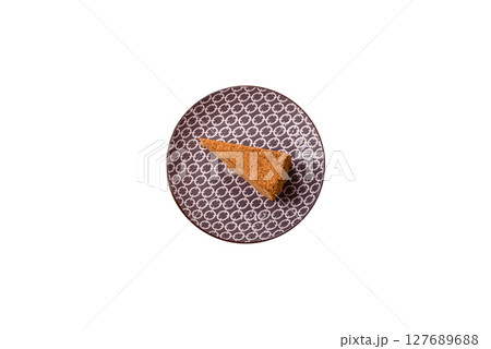A slice of honey puff cake or pumpkin, carrot and cream pie, vegan sweets 127689688
