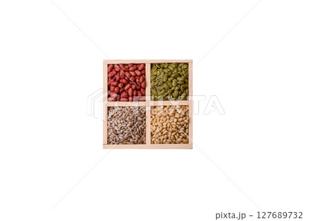 A box of peanuts and cedar nuts and sunflower and pumpkin seeds 127689732