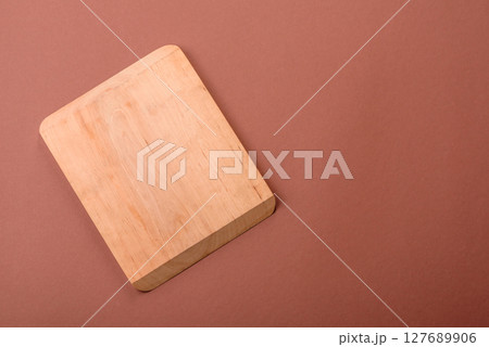 Empty wooden cutting board on a monochrome brown background 127689906