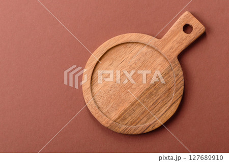 Empty wooden cutting board on a monochrome brown background 127689910