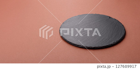 Empty ceramic plate on a monochrome brown background 127689917