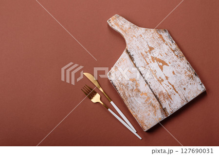 Empty wooden cutting board on a monochrome brown background 127690031