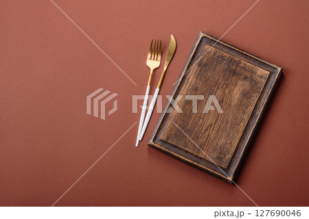 Empty wooden cutting board on a monochrome brown background Empty wooden cutting board on a monochrome brown background 127690046