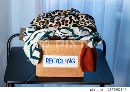 Box of used clothing marked for recycling. Eco friendly lifestyle. Closet management. 127690143