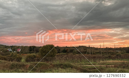 Witness a Stunning Sunset Over Wide Fields, Accompanied by a Dramatic and Colorful Sky Witness a Stunning Sunset Over Wide Fields, Accompanied by a Dramatic and Colorful Sky 127690332