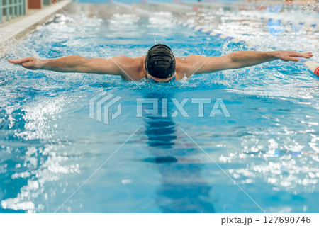 Man having a workout in the swimming pool 127690746