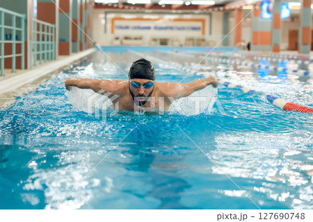 Man having a workout in the swimming pool 127690748