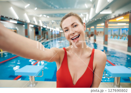 Pretty fit young woman in red swimsuit in the pool 127690802