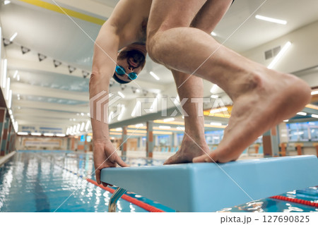 Man having a workout in the swimming pool and getting ready to jump 127690825