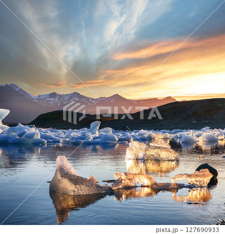 Ramarkable landscape with floating icebergs in Jokulsarlon glacier lagoon at sunset. 127690933