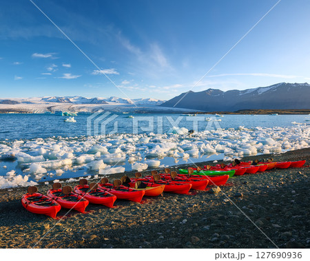 Impressive Kayaks on the shore of Jokulsarlon glacier lagoon at sunset. 127690936