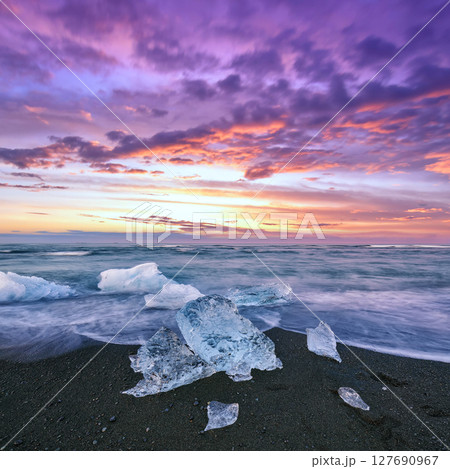 Impressive pieces of the iceberg sparkle on famous Diamond Beach at  Jokulsarlon lagoon during sunset. 127690967