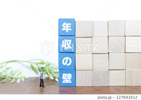 年収の壁と働き方の制限をイメージしたミニチュア構図 年収の壁と働き方の制限をイメージしたミニチュア構図 127691612