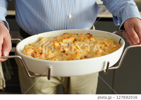 家族に自家製パスタをふるまうイタリア人中年男性 家族に自家製パスタをふるまうイタリア人中年男性 127692016