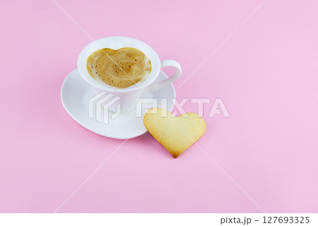 Cup of coffee and heart shape cookies on pink background. 127693325