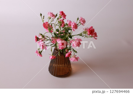 花瓶に挿したミニバラ 127694466