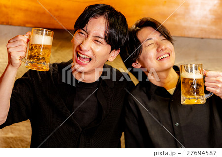 居酒屋で乾杯する男性 127694587