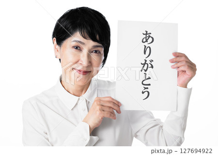 ありがとうと書かれた紙を持ちにっこりと微笑む中年女性 ありがとうと書かれた紙を持ちにっこりと微笑む中年女性 127694922