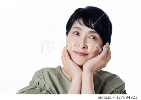 スキンケアの効果を実感しうっとりとした表情の中年女性 127694923