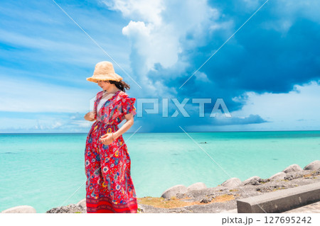 南国ビーチリゾートのワンピース姿の若い女性 127695242