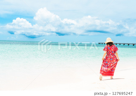 南国ビーチリゾートのワンピース姿の若い女性 127695247