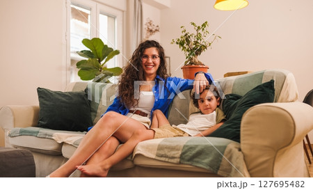 Mother and son relaxing on sofa at home, enjoying quality time together 127695482