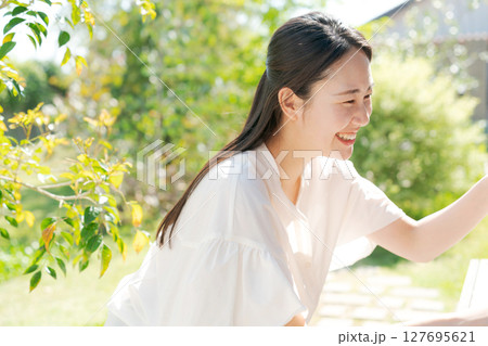 芝生にある庭で微笑む女性 芝生にある庭で微笑む女性 127695621