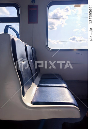 empty seats in train cabin during sunny afternoon ride in countryside. closeup. 127695644
