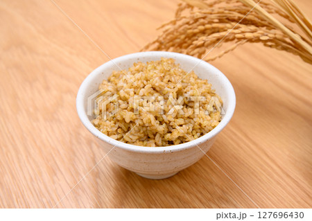 木目テーブル背景の茶碗に玄米ごはんと稲穂 木目テーブル背景の茶碗に玄米ごはんと稲穂 127696430