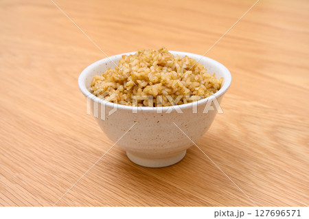 木目テーブル背景の茶碗に玄米ごはんと稲穂 木目テーブル背景の茶碗に玄米ごはんと稲穂 127696571