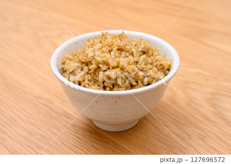 木目テーブル背景の茶碗に玄米ごはんと稲穂 木目テーブル背景の茶碗に玄米ごはんと稲穂 127696572