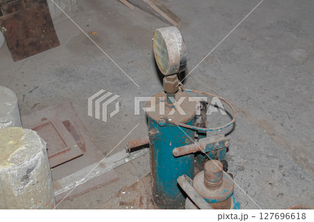 Close-up view of old industrial pressure testing equipment with gauge on concrete floor 127696618